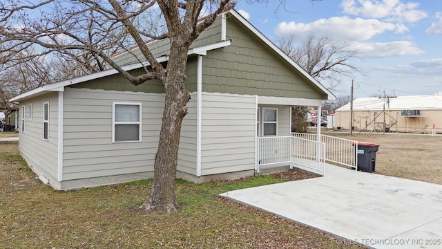 view of home's exterior with a patio area and a lawn