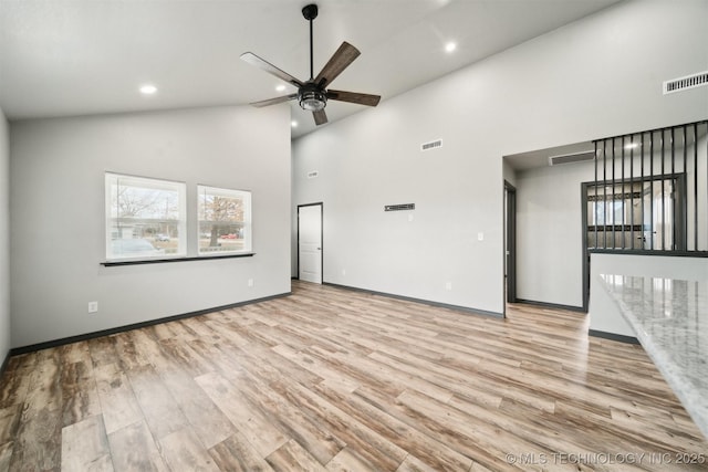 unfurnished living room featuring ceiling fan, high vaulted ceiling, and light hardwood / wood-style floors