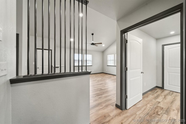 hallway with lofted ceiling and light hardwood / wood-style flooring