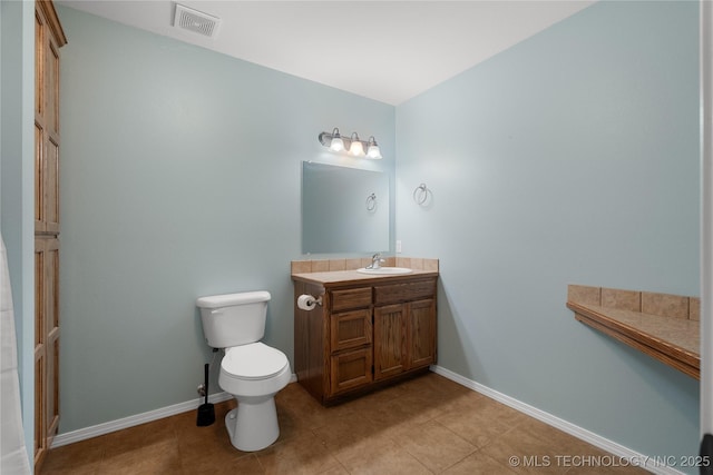 bathroom with tile patterned flooring, vanity, and toilet