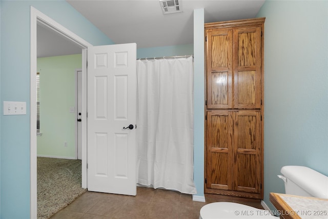 bathroom with vanity, tile patterned flooring, toilet, and walk in shower