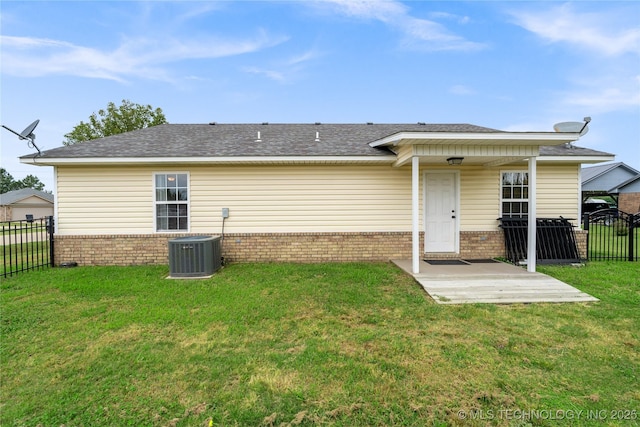 rear view of house with a patio, a yard, and central AC