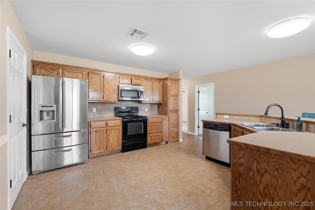 kitchen with tasteful backsplash, appliances with stainless steel finishes, and sink