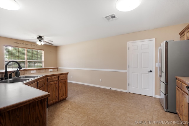 kitchen featuring sink, stainless steel refrigerator, and ceiling fan