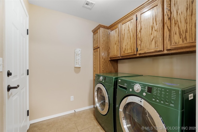 laundry room featuring cabinets, separate washer and dryer, and light tile patterned floors