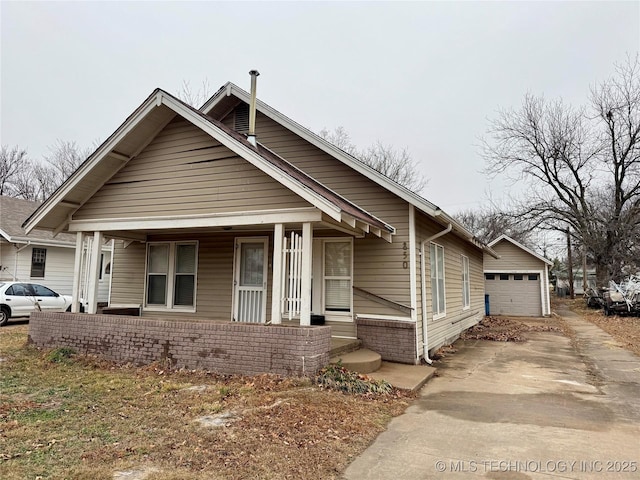 bungalow-style home featuring a garage, an outdoor structure, and covered porch