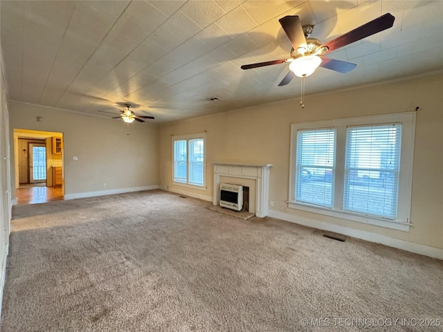 unfurnished living room with heating unit, ceiling fan, ornamental molding, and carpet