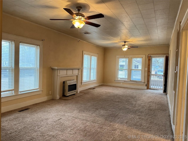 unfurnished living room featuring heating unit, ornamental molding, light colored carpet, and ceiling fan