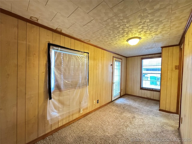 interior space with ornamental molding and wood walls