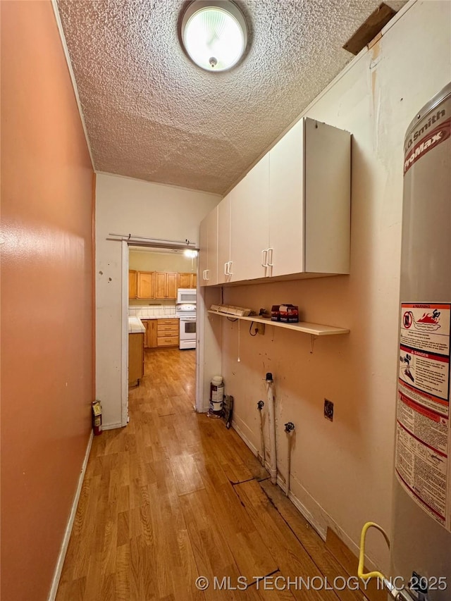 washroom with light hardwood / wood-style flooring, electric dryer hookup, cabinets, gas water heater, and a textured ceiling