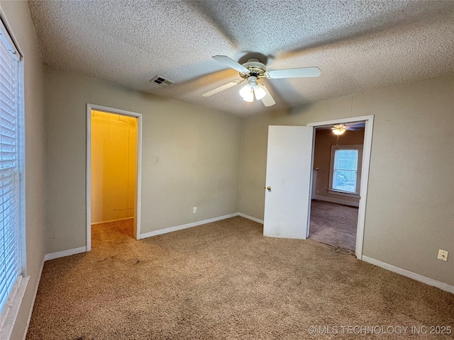 unfurnished bedroom featuring ceiling fan, carpet floors, and a textured ceiling