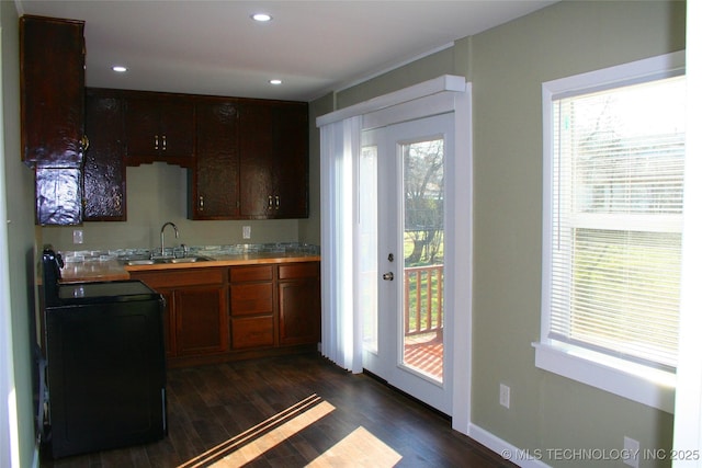 kitchen featuring stove, sink, and dark hardwood / wood-style floors