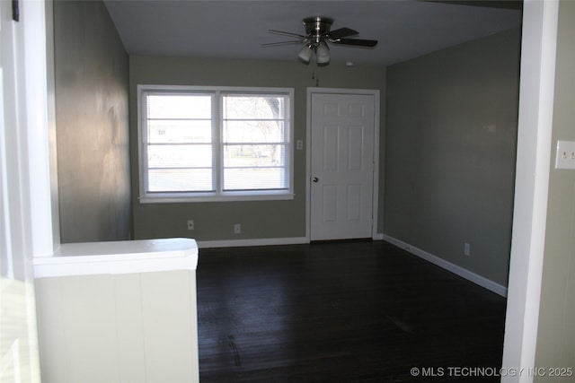 spare room with dark wood-type flooring and ceiling fan