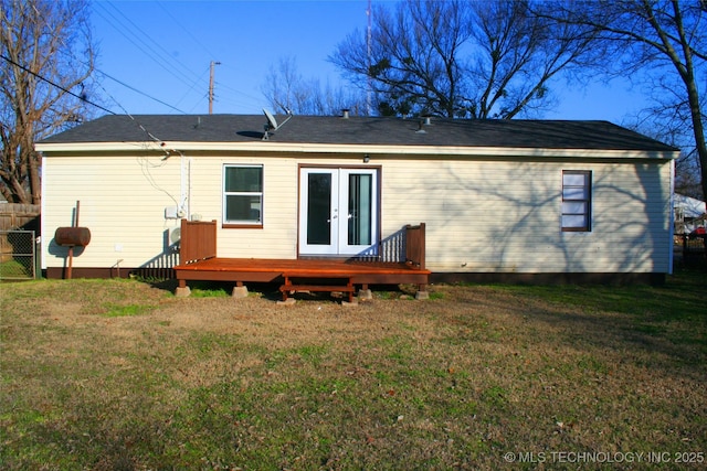 rear view of house featuring a yard, a deck, and french doors