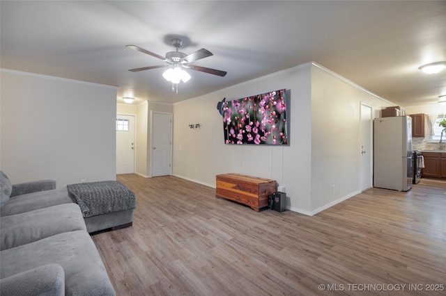 living room with ornamental molding, sink, ceiling fan, and light hardwood / wood-style floors