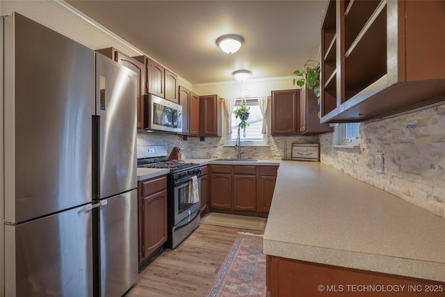 kitchen with tasteful backsplash, crown molding, appliances with stainless steel finishes, and sink