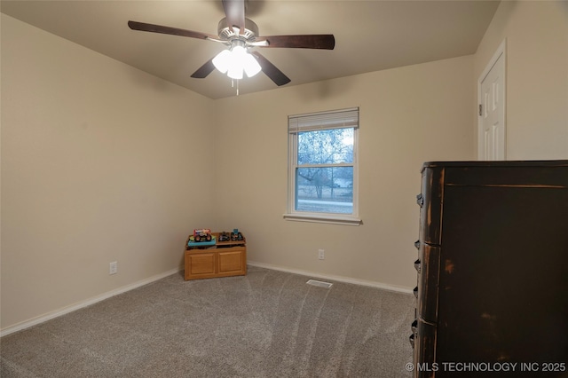 unfurnished bedroom with black refrigerator, ceiling fan, and carpet flooring