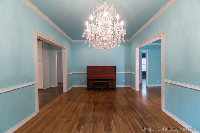 unfurnished dining area featuring ornamental molding, a chandelier, wood finished floors, and baseboards