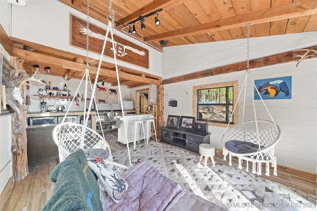 living room featuring vaulted ceiling with beams, track lighting, wooden ceiling, and light hardwood / wood-style flooring