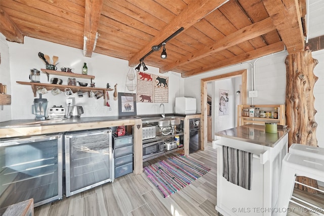 kitchen with wood ceiling, beverage cooler, sink, and beamed ceiling