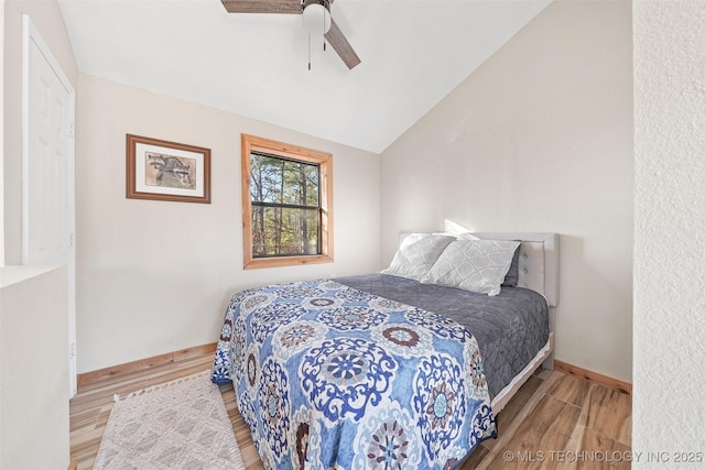 bedroom featuring hardwood / wood-style floors, vaulted ceiling, and ceiling fan