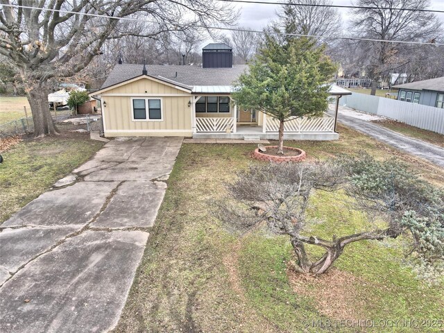 ranch-style home with covered porch and a front lawn