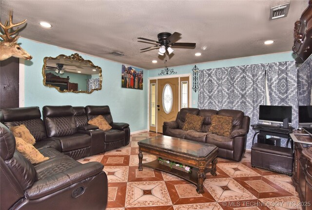 living room featuring light tile patterned floors, a textured ceiling, and ceiling fan