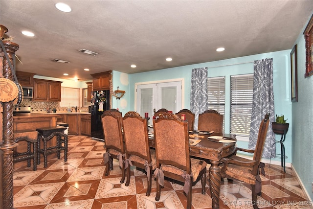 dining space with a textured ceiling and french doors