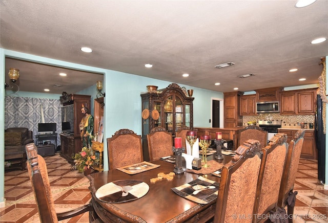 dining room featuring light parquet flooring and a textured ceiling