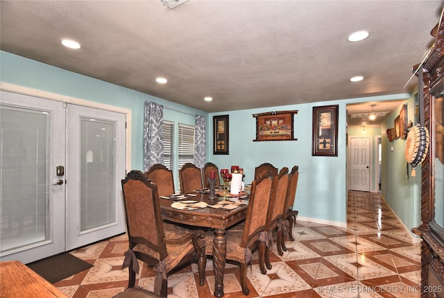 dining area featuring a textured ceiling and french doors