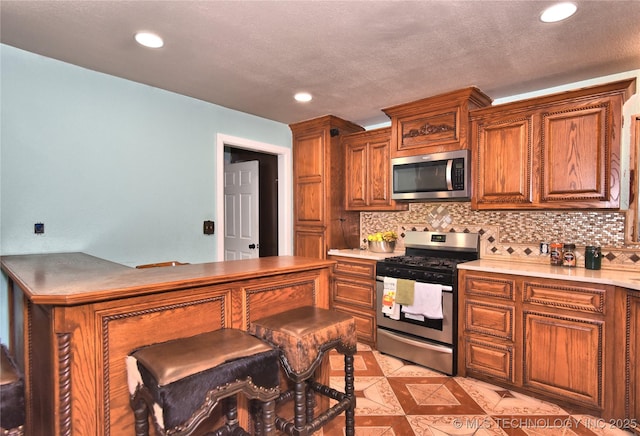 kitchen featuring tasteful backsplash, appliances with stainless steel finishes, and a textured ceiling