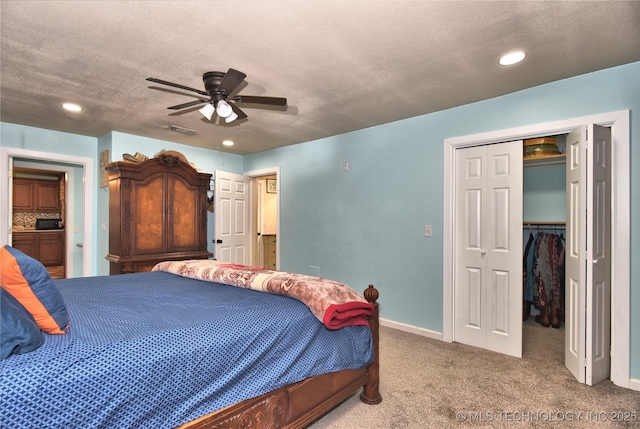 carpeted bedroom featuring ceiling fan, a closet, and a textured ceiling