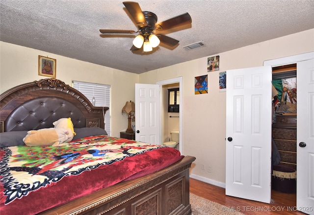 bedroom featuring hardwood / wood-style flooring, ceiling fan, a textured ceiling, and ensuite bath