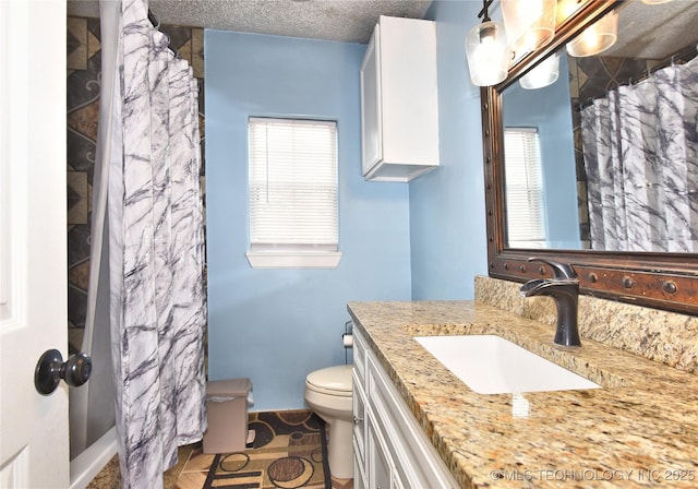 bathroom with vanity, tile patterned floors, a textured ceiling, and toilet