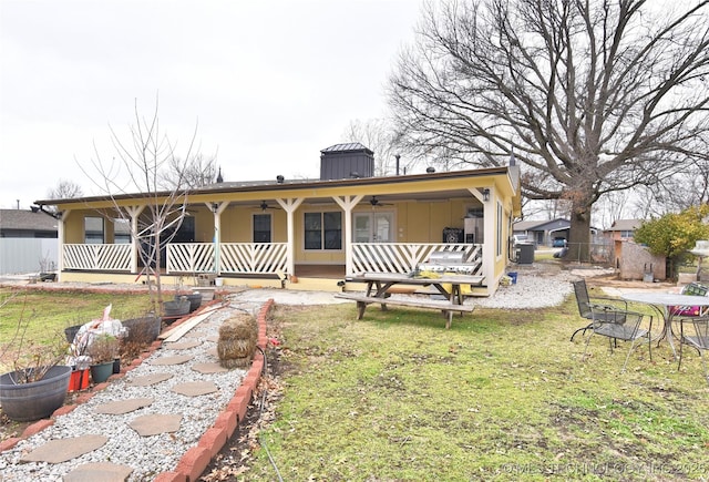 back of house featuring a yard, covered porch, and ceiling fan