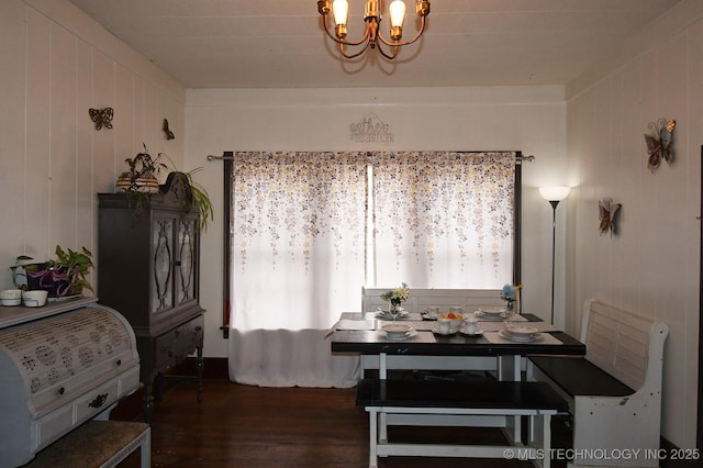 dining space with a notable chandelier and dark hardwood / wood-style flooring