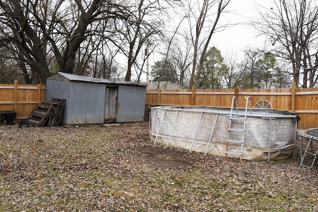 view of yard with an empty pool and a storage shed