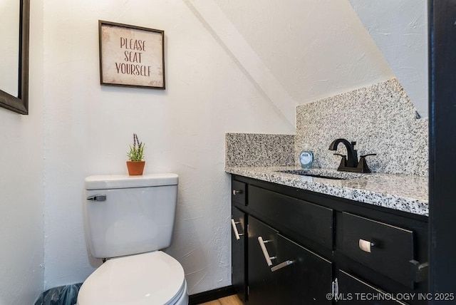 bathroom featuring vanity, decorative backsplash, and toilet