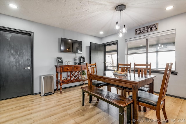 dining room featuring a textured ceiling and light hardwood / wood-style floors