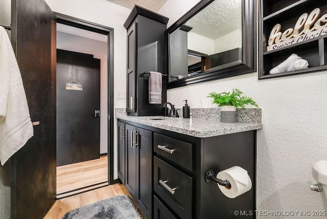 bathroom with vanity, hardwood / wood-style floors, and a textured ceiling