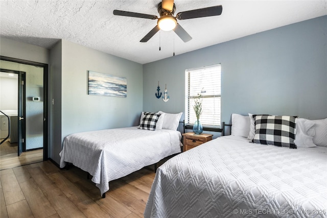 bedroom featuring hardwood / wood-style floors, a textured ceiling, and ceiling fan