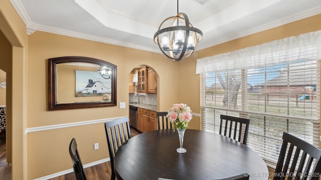 dining space with a raised ceiling, crown molding, dark hardwood / wood-style floors, and an inviting chandelier