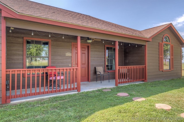 rear view of property with ceiling fan, a yard, a porch, and a patio area