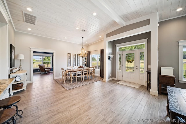 foyer with lofted ceiling with beams, a chandelier, a wealth of natural light, and light hardwood / wood-style floors