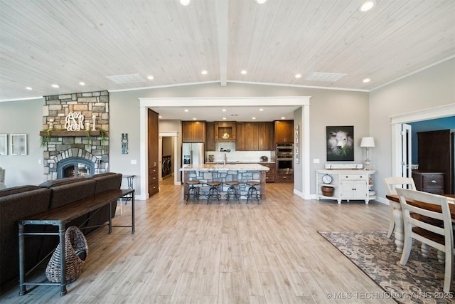 living room featuring crown molding, lofted ceiling with beams, light hardwood / wood-style floors, and wooden ceiling