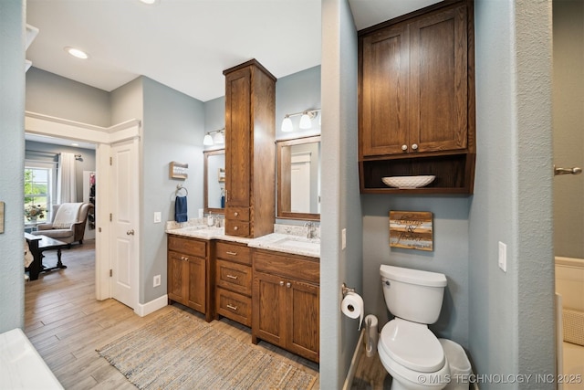 bathroom featuring vanity, hardwood / wood-style flooring, and toilet