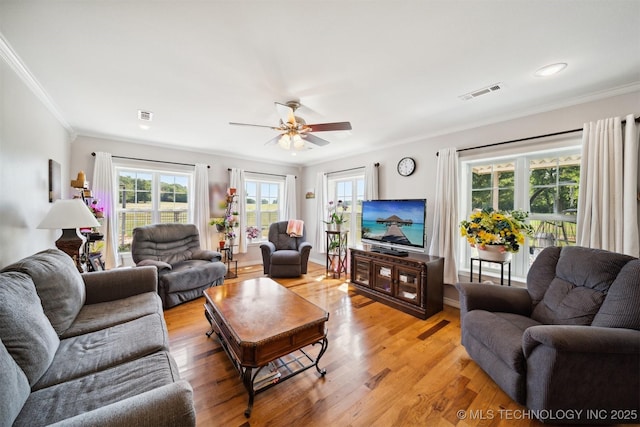 living room featuring crown molding, light hardwood / wood-style floors, and ceiling fan