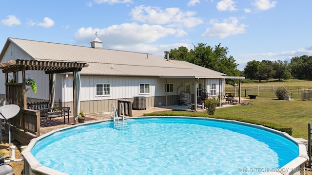 view of swimming pool with cooling unit, a lawn, and a patio