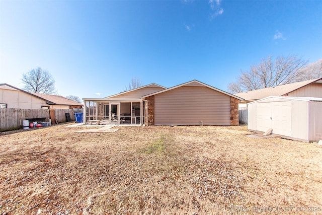 back of house with a sunroom and a storage unit