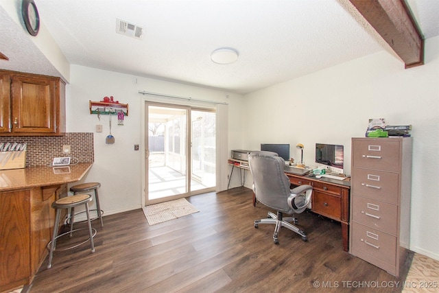 office space with beam ceiling, dark wood-type flooring, and a textured ceiling